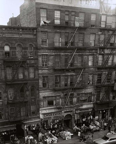 An apartment building that has a fire escape down the front. The words "CASA EVITA" are printed on a sign in front.
