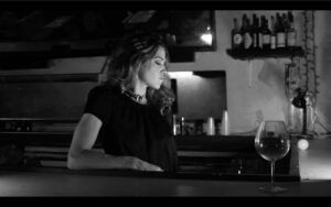 A bartender looks sadly into the distance.