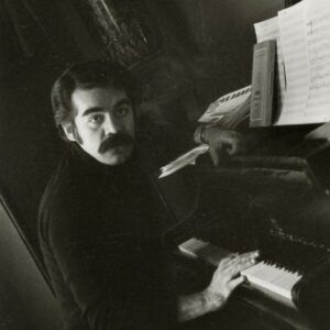 Roger Cabán sitting at a piano.