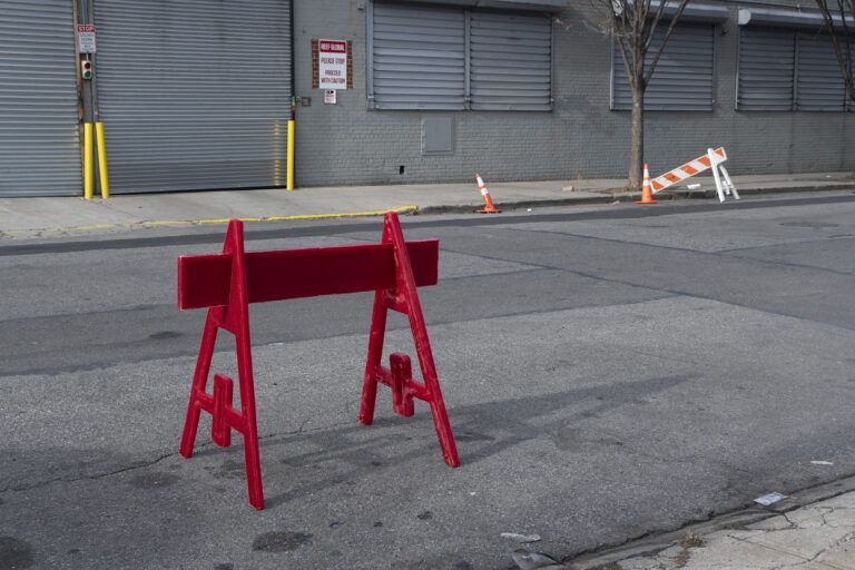 A life-size, freestanding police barrier cast entirely in red votive wax. Sculptural installation, performance.