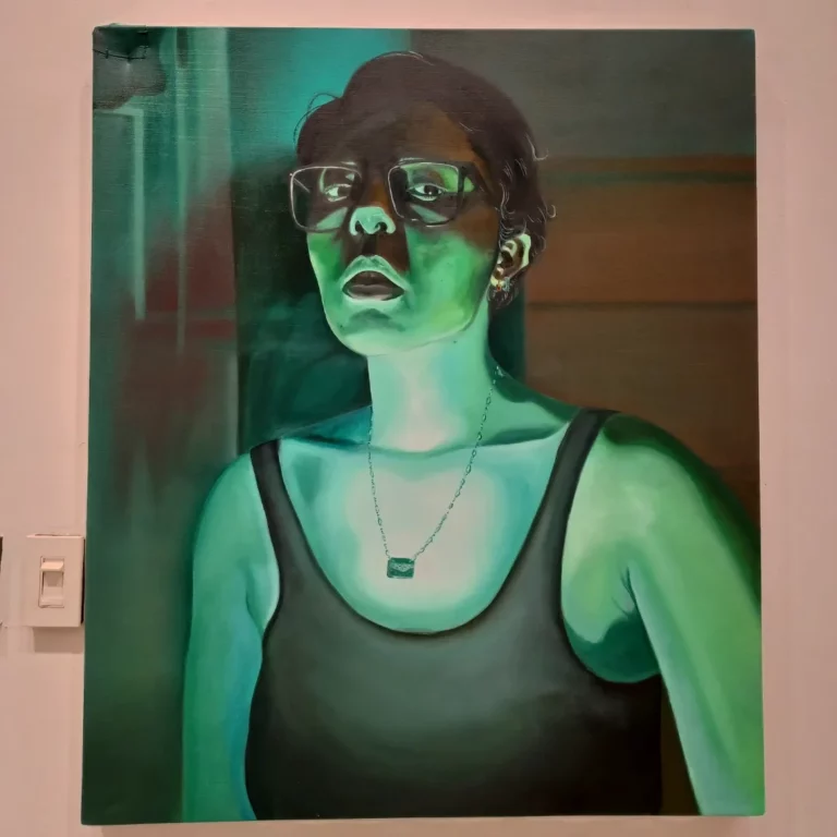 A green-tinted self-portrait, where the artist is lit from below with a serious expression.