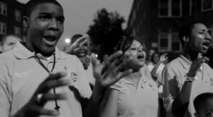 A group of people participating in outdoor singing/prayer.